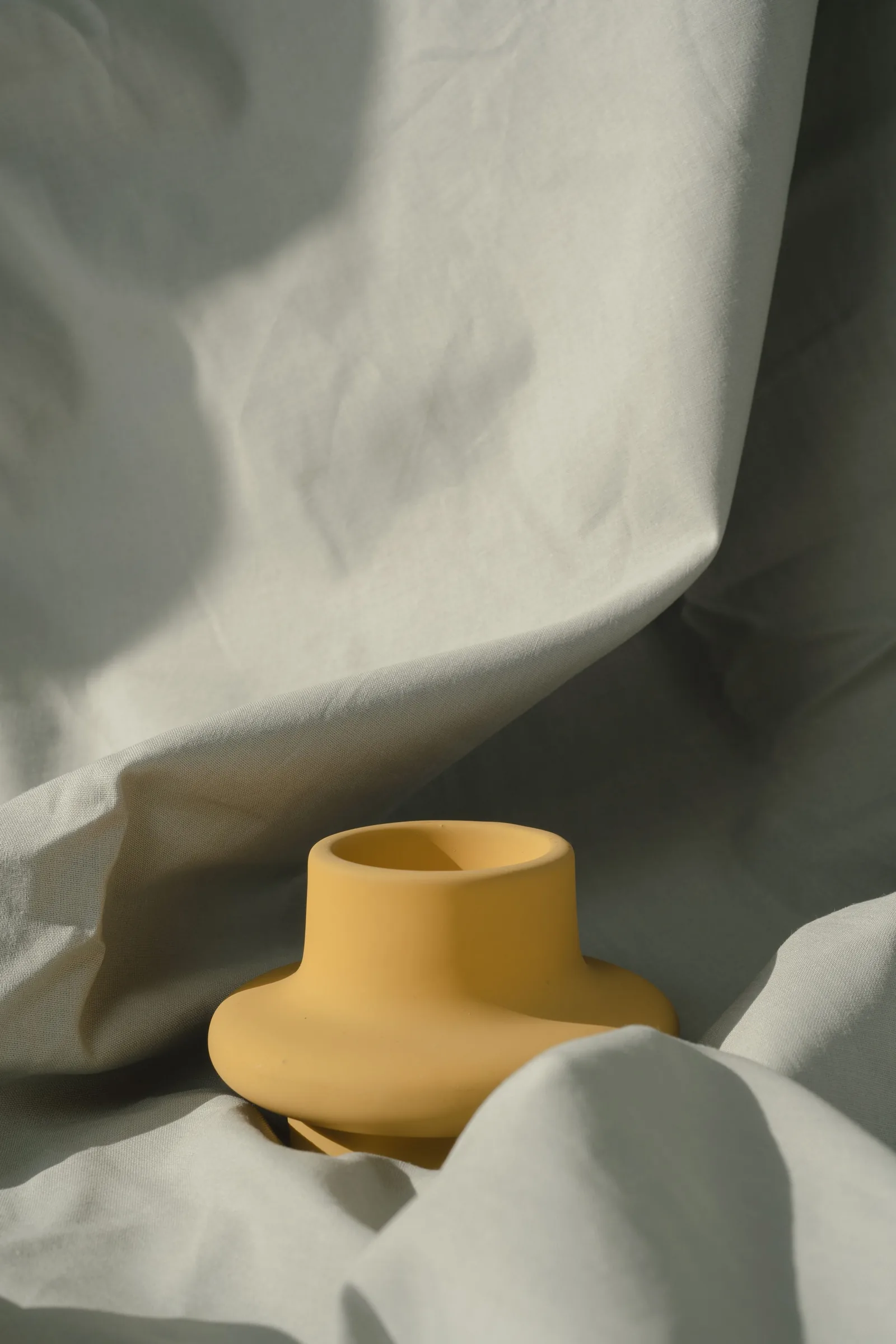 A single yellow ceramic vase